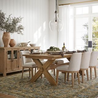 Chairs surrounding Tocsana Extending Dining Table against white walls. 