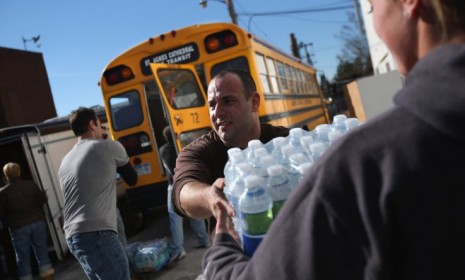 Volunteers unload water at an aid distribution center at the Long Beach Ice Arena in New York on Nov. 4.