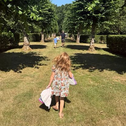 Prince Archie, Prince Harry and Princess Lilibet walking in the grass at Althorp