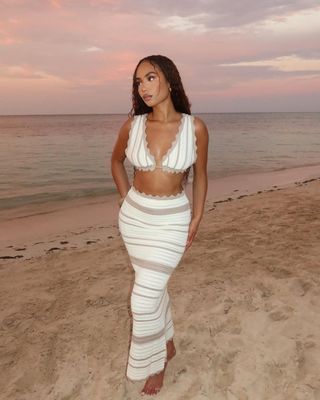 Symphani Soto wears a knit, striped two piece and mermaid braids