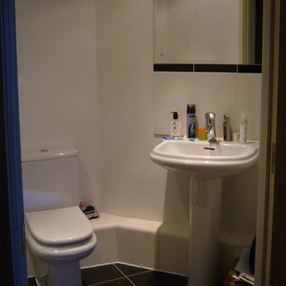 bathroom with white wall and washbasin and toilet