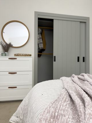 An IKEA pax wardrobe painted sage green with shiplap effect doors