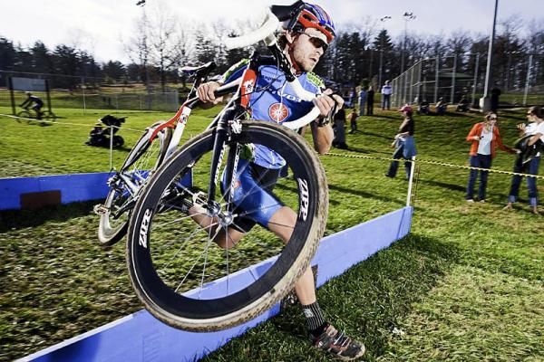 An elite men's rider runs the barrier section.