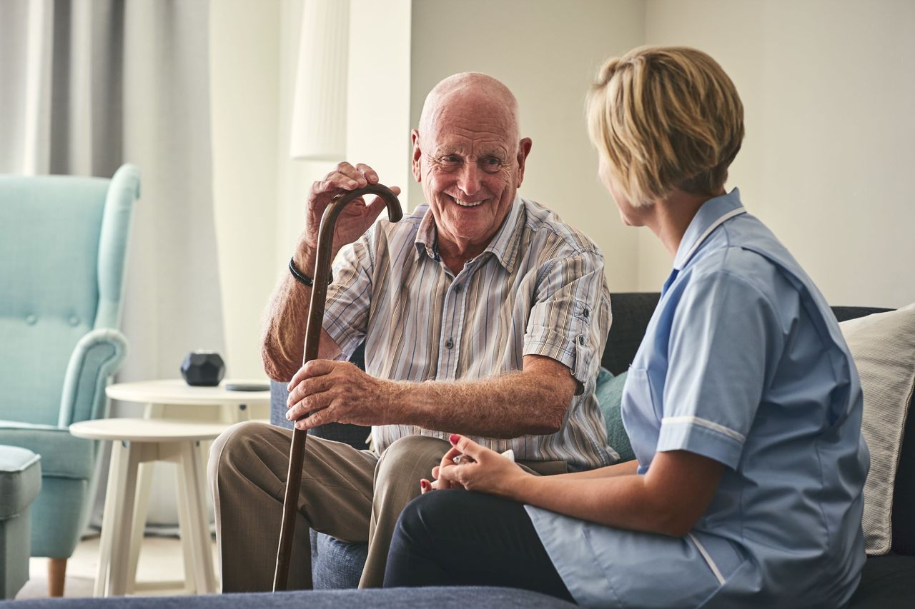 A nurse sitting with a patient in a nursing home. 