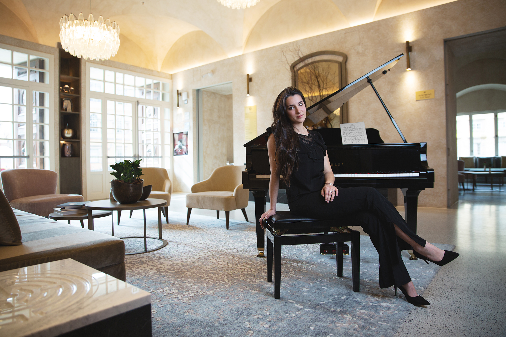 Composer Felicity Luccesi sits at the baby grand piano inside the lounge at Grand Universe Lucca