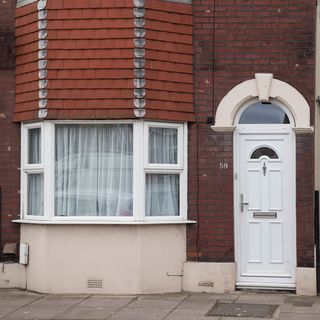 exterior with white door and brick wall