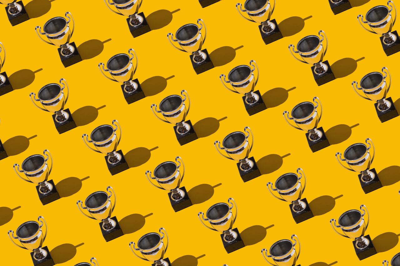 Trophy cups winner champion cups pattern with hard shadow on yellow background.