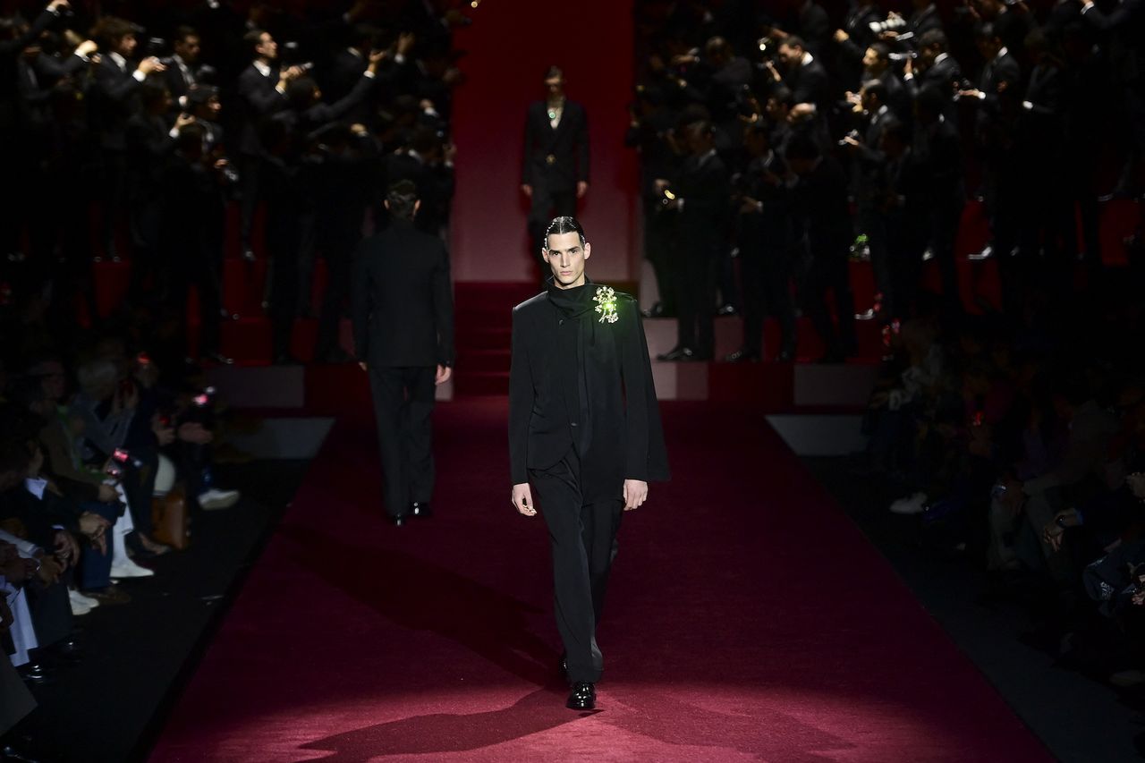 Dolce &amp; Gabbana at Milan Fashion Week Men’s A/W 2025 featuring model in black suit on a red runway