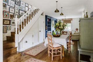 cottage staircase ideas open plan dining and living room with gallery wall running up the stairs
