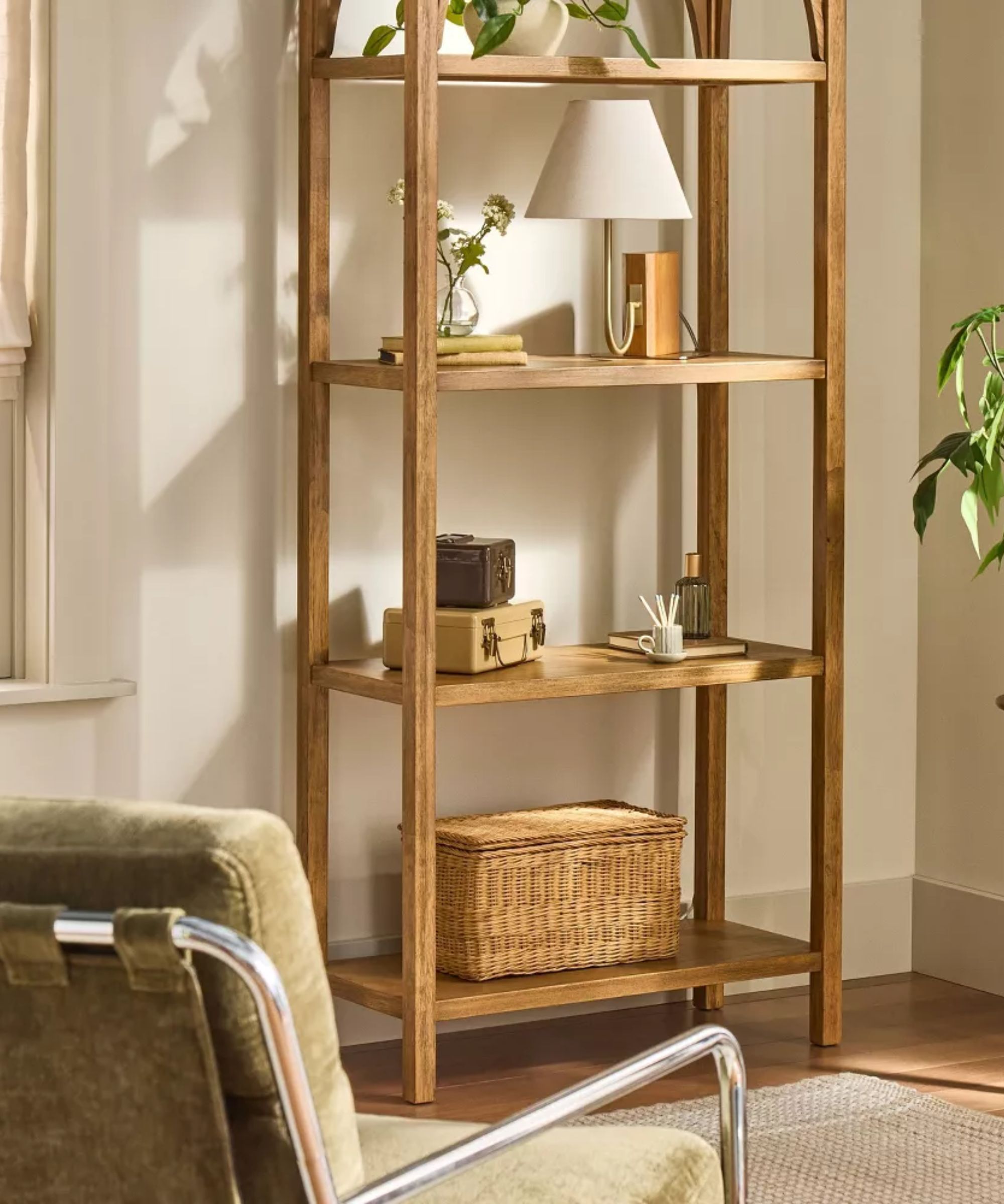 a living room shelving unit with decor on each shelf including a lamp, a vase with flowers, some boxes, and matches