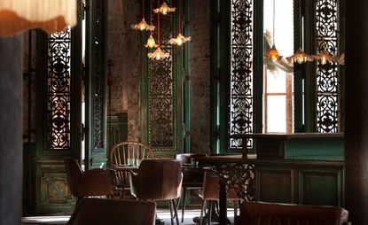 Kazbek restaurant in Moscow with wood and metal shutters, wooden floor and brown and green furniture