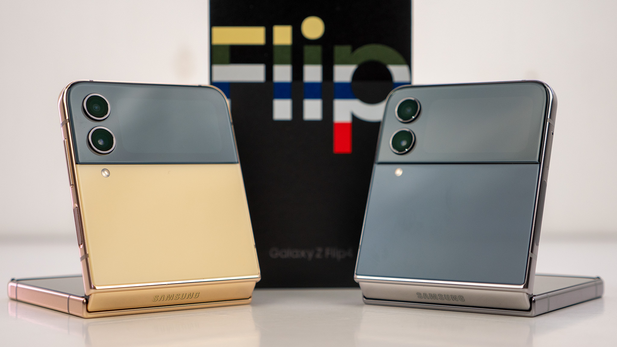 Samsung Galaxy Z Flip 4 Maßgeschneiderte Edition, eines mit gelben Backplates mit goldenem Rahmen und das andere mit marineblauen Backplates und silbernem Rahmen