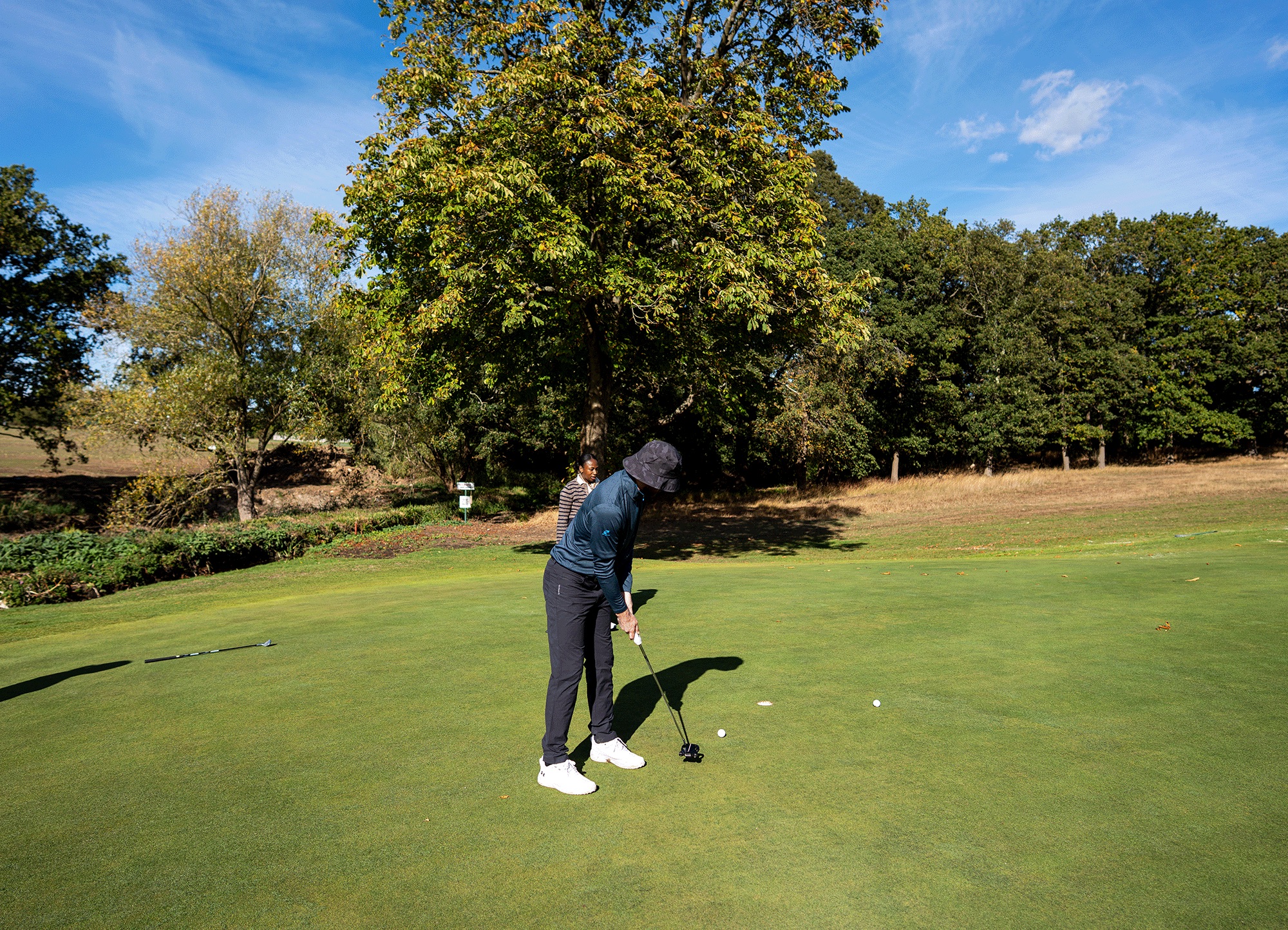 Baz Plummer rolling a short putt in on the green at Hadley Wood Golf Club