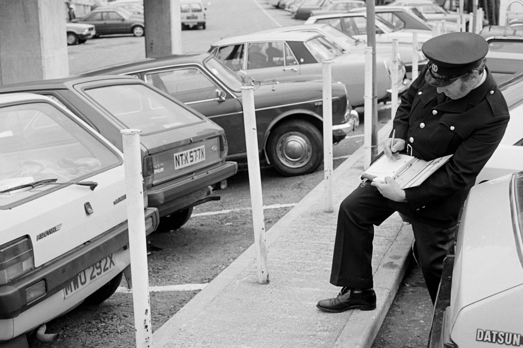 A warden writes a parking ticket in Newport, Wales, on 20th September 1984