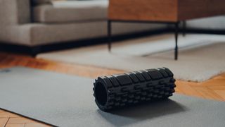 A foam roller on an exercise mat