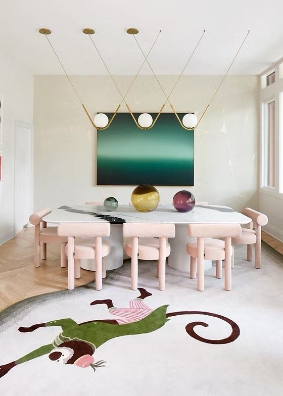 Cara Woodhouse's dining room with statement lighting and art, pale pink dining room chairs and an abstract rug with a dressed monkey on it