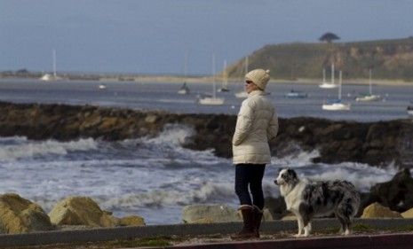 A San Francisco woman watches as waves hit the Pacific coast Friday: California didn&amp;#039;t incur major damages from Japan&amp;#039;s earthquake and tsunami... yet.