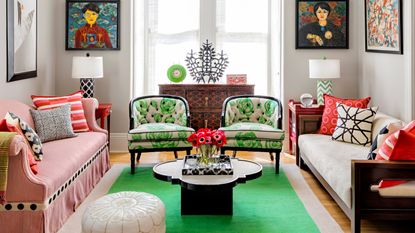  living room with pink sofa, white sofa, green and white patterned chairs, and bold green rug