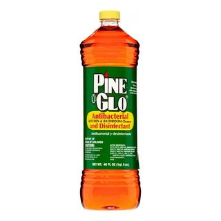 A clear bottle of Pine Glo Antibacterial Disinfectant Household Cleaner with green label and yellow lid