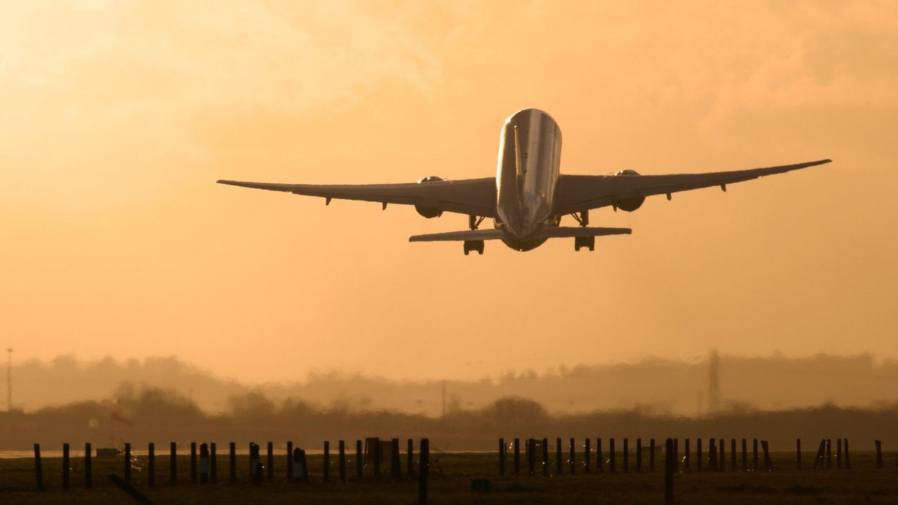 Airplane taking off at sunset