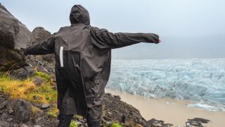 Man in his rain poncho enjoying the view on glacier