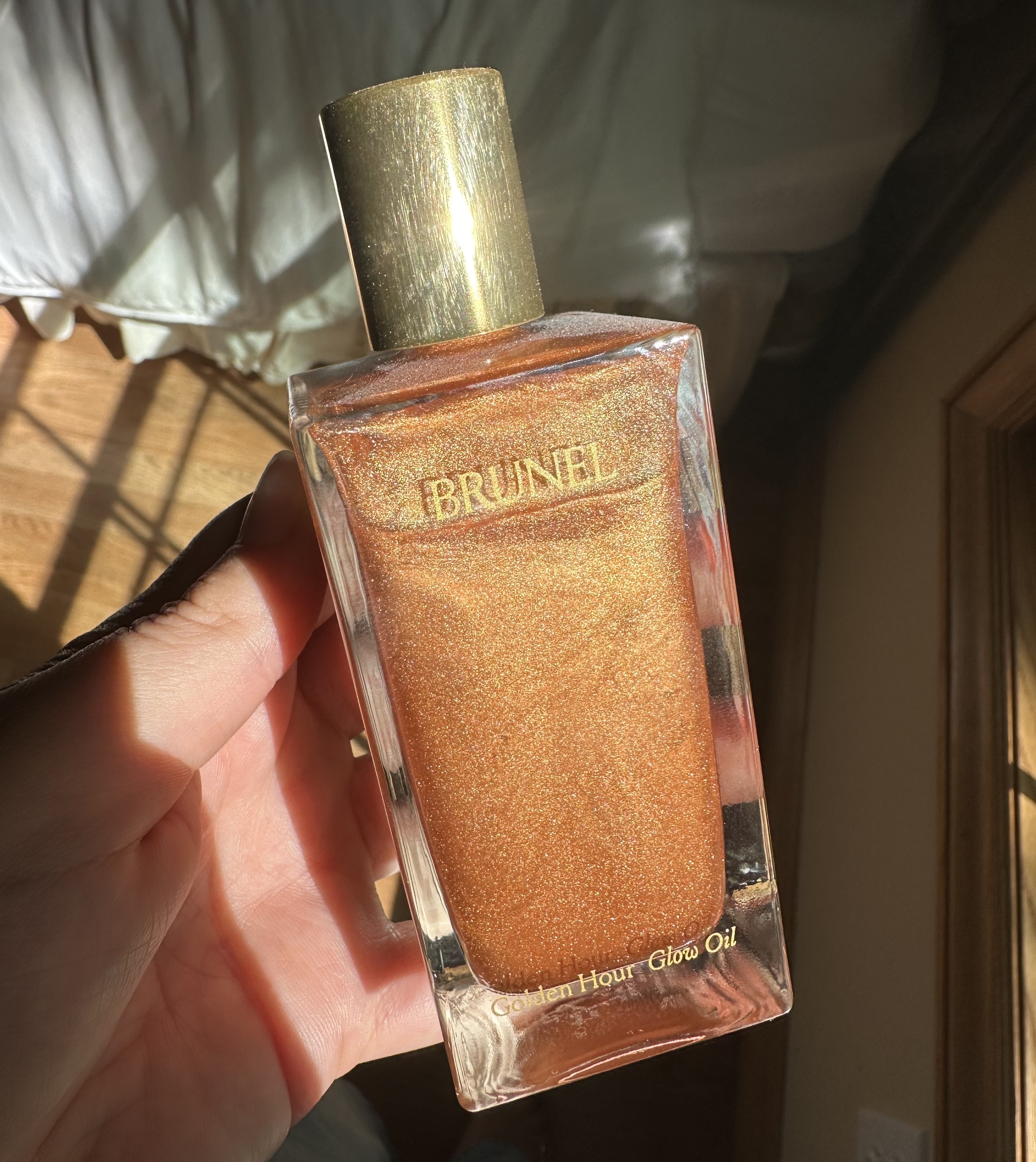 Beauty editor Kaitlyn McLintock holding Brunel Golden Hour Glow Body Oil.