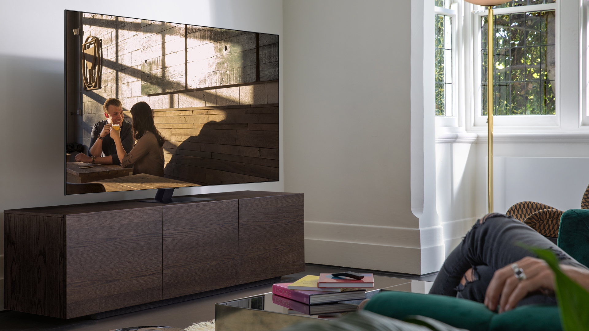 Couple on sofa watches couple on park bench on Samsung TV