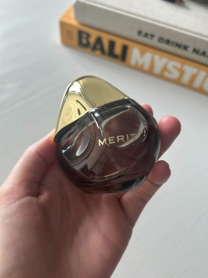 Junior beauty editor Grace Lindsay holding the Merit Retrospect perfume