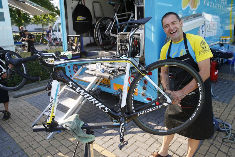 Astana mechanic works away on a bike