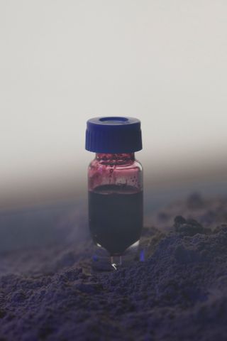 A small bottle containing purple pigment