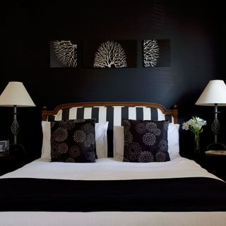 black and white double bed with white bedside lamps