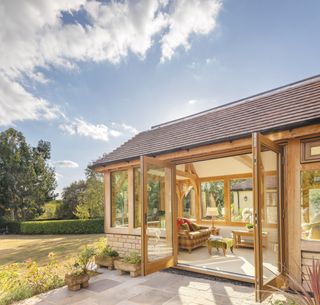 oak frame sunroom with open patio doors and garden