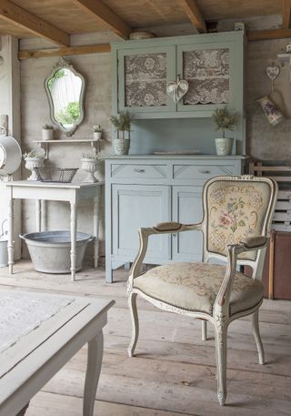 Vintage blue cabinet and tapestry chair in garden room