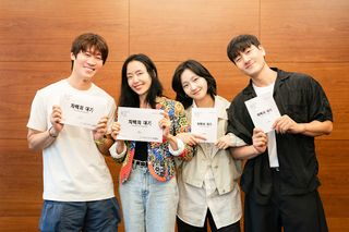 Actors from the Netflix k-drama 'The Price of Confession' link their arms while holding up scripts.