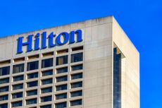 The top portion of a building displaying a bold "Hilton" sign.