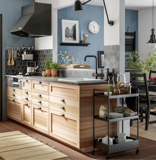 An example of portable kitchen island ideas showing a wooden kitchen unit with drawers and a built in sink next to a trolley