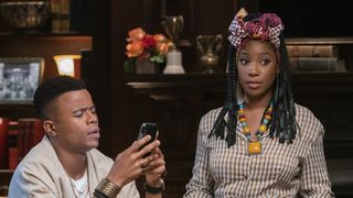 Marque Richardson (as Reggie Green) is looking at his phone in confusion while Ashley Blaine Featherson (as Joelle Brooks) looks off camera in dear white people