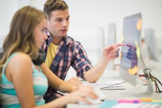 Classmates doing assignment together in the computer room in college