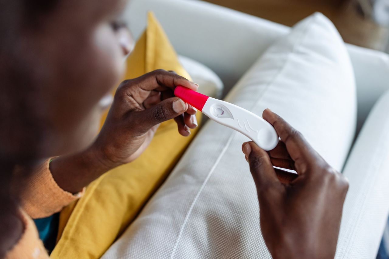 Early signs of pregnancy illustrated by woman holding pregnancy test