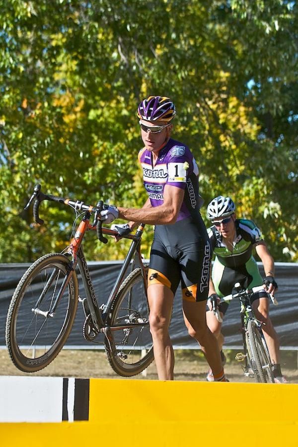 Ryan Trebon runs across the barriers while behind him, Jeremy Powers prepares to dismount