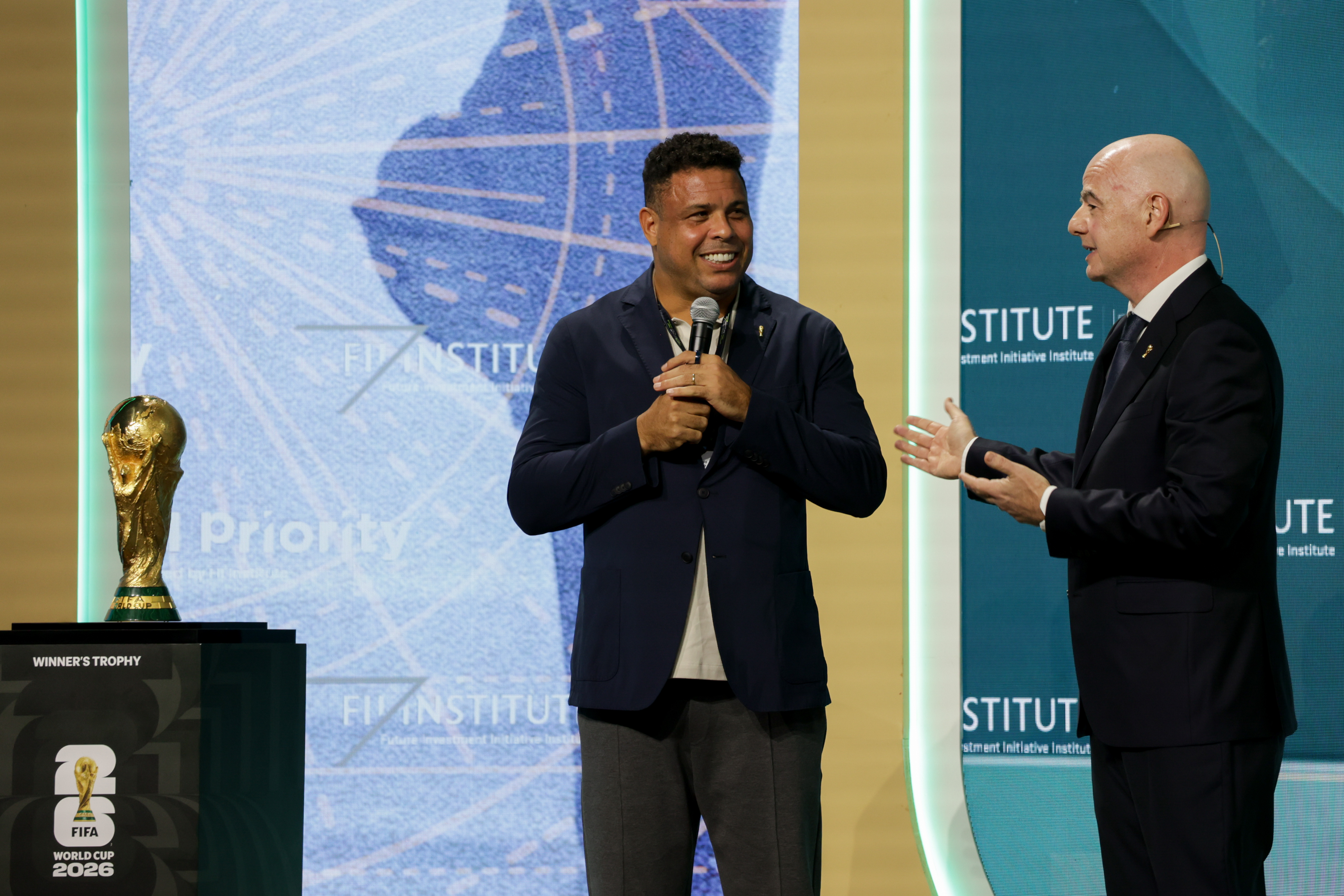 Former professional soccer player Ronaldo Nazario, left, and Gianni Infantino, president of the Federation International Football Association (FIFA), during the Future Investment Initiative (FII) Priority Summit conference in Miami, Florida, US, on Friday, March 27, 2026. The summit is designed as engines of actionable change with this year's theme of "Capital in Motion." Photographer: Zak Bennett/Bloomberg