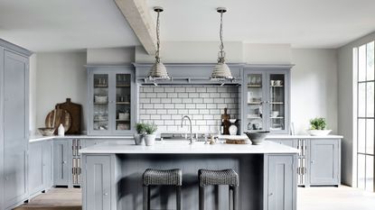 pale blue kitchen with island and white tiles