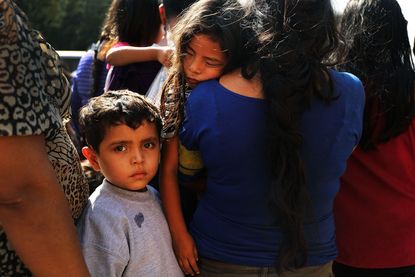 Dozens of women, men and their children, many fleeing poverty and violence in Honduras, Guatamala and El Salvador, arrive at a bus station following release from Customs and Border Protection