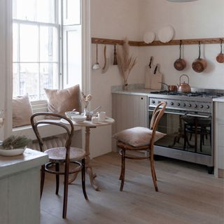kitchen with wooden floor, bistro chairs and window seat above radiator