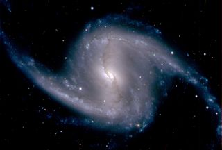 This photo from the new Dark Energy Camera, taken in September 2012, shows the barred spiral galaxy NGC 1365, in the Fornax cluster of galaxies, which lies about 60 million light years from Earth.