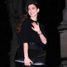 Anne Hathaway smiles and waves