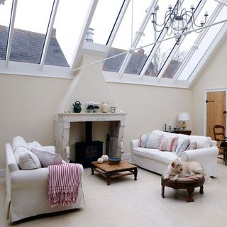 conservatory with living area with fireplace and white sofa and coffee table
