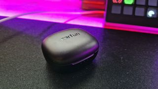 EarFun Air Pro 3 on a mouse mat next to pink RGB lighting