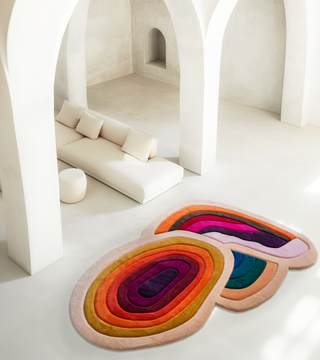 a colorful rug in an all white room