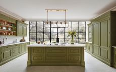 green kitchen with island and white marble worktops